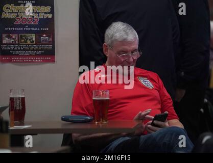 An England fan looks at his phone at the 76 Lounge at the Lamex Stadium, Stevenage, while watching a screening of the FIFA World Cup Quarter-Final match between England and France. Picture date: Saturday December 10, 2022. Stock Photo