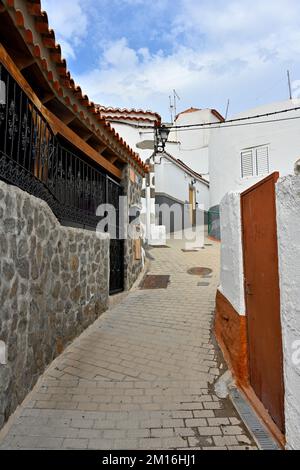 Small narrow street in the mountain village of Fataga with stone walls by houses, Gran Canaria Stock Photo