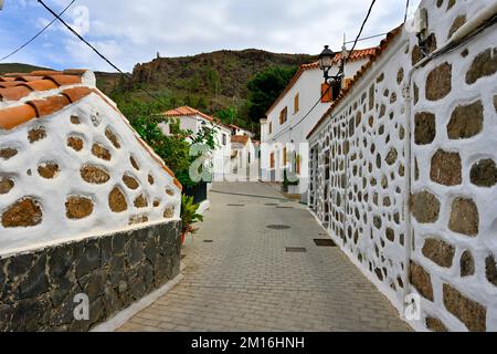 Small narrow street in the mountain village of Fataga with stone walls by houses, Gran Canaria Stock Photo