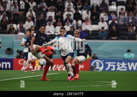 Al Khor, Qatar, on December 9, 2022. England's midfielder Phil Foden vies for the ball with French defender Raphael Varane and Antoine Griezmann during the  World Cup FIFA Qatar 2022 round of quarter finals match between England and France at Al Bayt Stadium in Al Khor, Qatar, on December 9, 2022. (Alejandro PAGNI / PHOTOXPHOTO) Credit: Alejandro Pagni/Alamy Live News Stock Photo