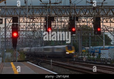 2 Avanti west coast class 221 diesel voyager trains passing a signal gantry and red signals on the west coast mainline at Crewe railway station Stock Photo