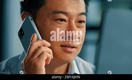Asian korean chinese man 40s businessman mature boss agent consultant male office worker calling client speak mobile phone business conversation on Stock Photo
