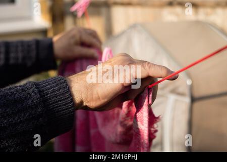 Close-up of an elderly mans hands pegging laundry Stock Photo