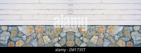 There is white painted wood paneling on the blue yellow ashlar wall, wood paneling and wall texture Stock Photo