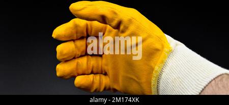 New and yellow protective work gloves isolated on black background Stock Photo