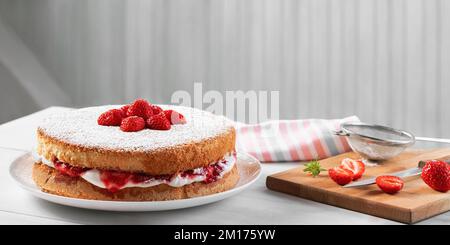 Two-layer Victoria cake with whipped cream, strawberry jam and fresh berries. Stock Photo