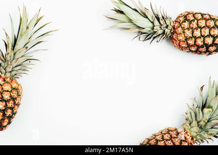 Pineapples on white background. Tropical fruits, healthy food. Top view, flat lay, copy space. Stock Photo