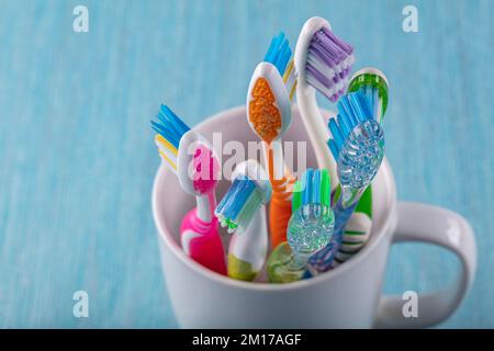 Toothbrushes in ceramic bowl on blurred background. Colorful toothbrushes, healthy tooth concept. Stock Photo