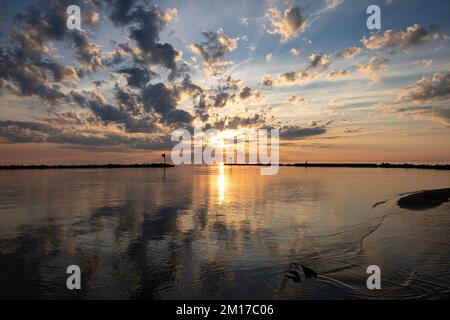 Serene Sunset Over Calm Lake With Reflective Water and Clouds Stock Photo