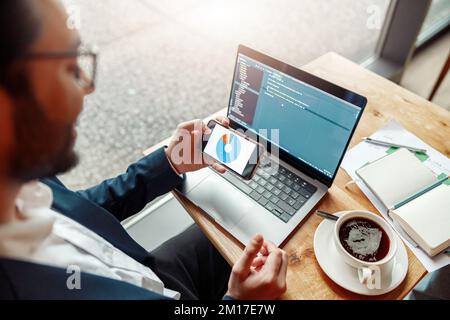 Young developer programmer freelancer in glasses working on project in cafe. Blurred background Stock Photo