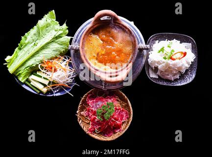 Korean spicy hot pot with beef meat and noodles on black background Stock Photo