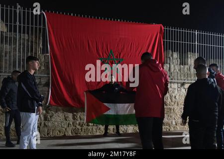 JERUSALEM, ISRAEL - DECEMBER 10: Young Palestinians pose with a Moroccan and Palestinian flag, as they celebrate Morocco's victory against Portugal after the FIFA World Cup Qatar 2022 Quarter Final match between Morocco and Portugal, in the old city on December 10, 2022 in Jerusalem, Israel. Morocco becomes first African side to enter FIFA World Cup semifinal after Portugal in Qatar. Credit: Eddie Gerald/Alamy Live News Stock Photo