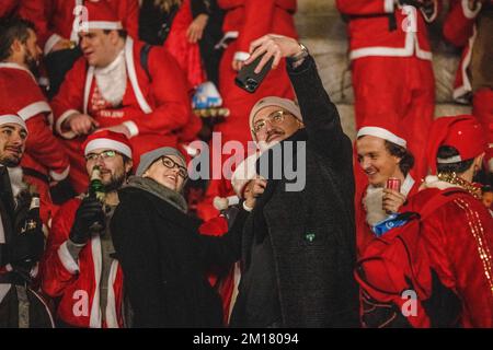 London, UK. 10th Dec, 2022. General public seen taking selfie with the Santa crowd. Santacon is an annual non-profit, non-political, non-religious, and non-sensical Christmas parade that takes place in London every December. Credit: SOPA Images Limited/Alamy Live News Stock Photo