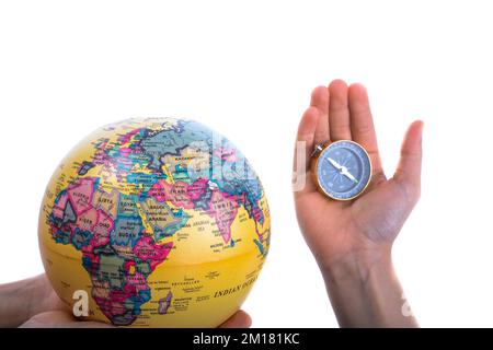Globe and compass in hand on white background Stock Photo