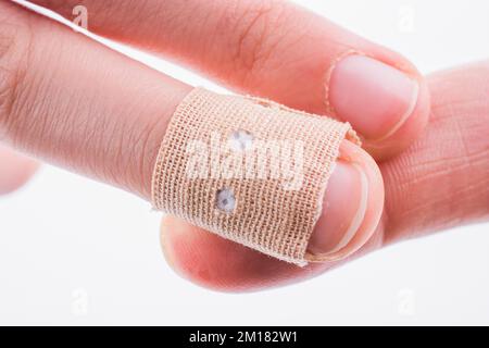 Finger in white bandage on a white background Stock Photo