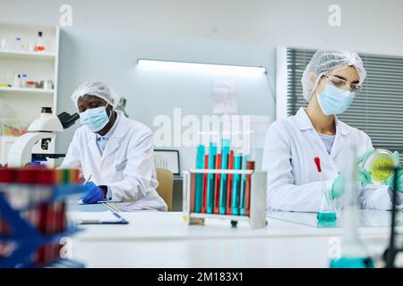 Medical laboratory with two workers and colored test tubes Stock Photo