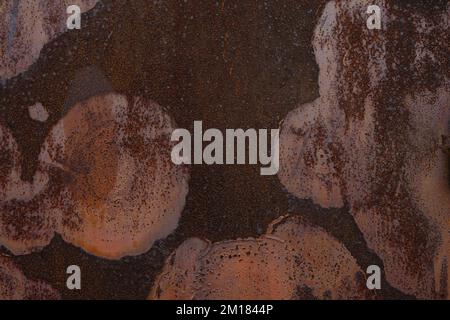 Close up of heavily rusted metal surface with peeling paint, corrosion texture and brown iron spots Stock Photo