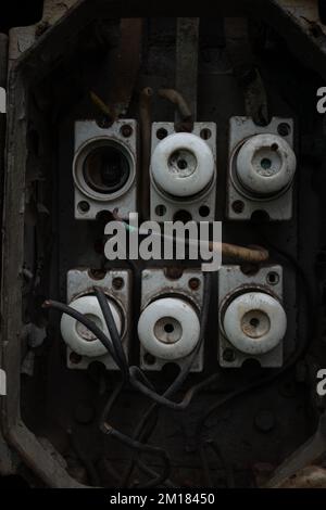 Old abandoned industrial electrical switchboard with heavy rust, broken covers and ceramic fuses Stock Photo