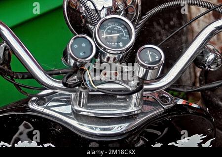 Close-up of the chrome handlebars of a vintage motorcycle scooter showing the speedo and other gauges Stock Photo