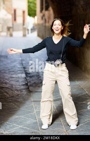 Delighted woman laughing on old street during holiday Stock Photo