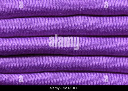 BACKGROUND TEXTURE - Folded pieces of purple knitted fabric Stock Photo