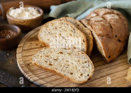 Homemade baking. Bread from whole wheat grains, wheat bran, seeds, bio-ingredients over rustic table background, healthy lifestyle. Stock Photo