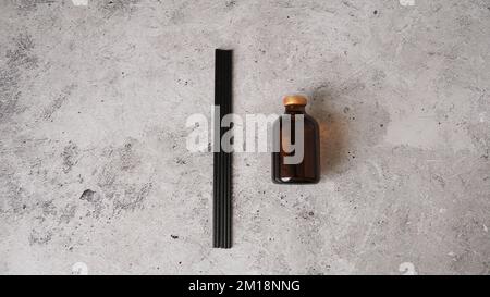 Aromatic reed diffuser bottle with black sticks on a dark marble background. Home perfume set. Sticks and a bottle of fragrance. Stock Photo