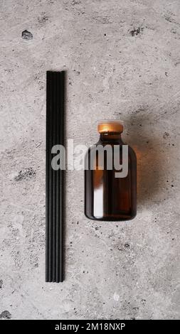Aromatic reed diffuser bottle with black sticks on a dark marble background. Home perfume set. Sticks and a bottle of fragrance. Stock Photo