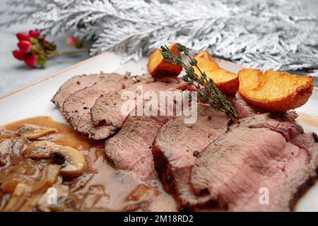 Baked veal with potatoes and mushrooms in sauce Stock Photo