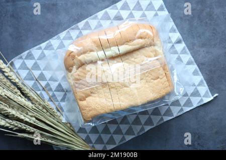 top view of baked bread in a plastic packet on black background  Stock Photo