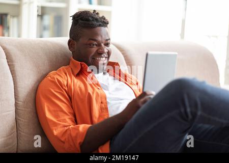 Portrait of happy african man using digital tablet at home Stock Photo