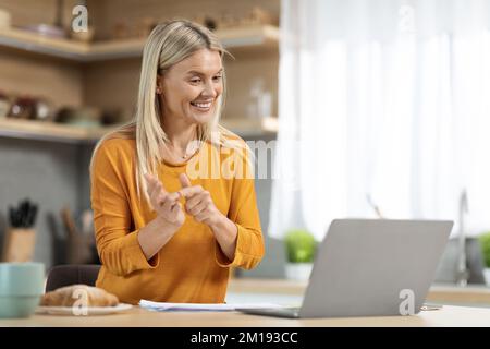 Middle aged woman having video conference with colleagues from home Stock Photo