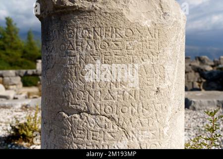 Antique greek inscriptions carved on the stone of the old ruins of an antique greek city. High quality photo Stock Photo