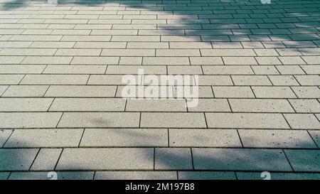 Abstract background of brickwork on the sidewalk, light spots and shadows from trees Stock Photo