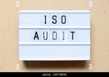 Lightbox with word ISO audit on wood background Stock Photo