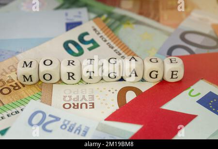 Mortgage sign on Euro banknotes, and red rising arrow. Concept of mortgage interest rates increase, inflation. Stock Photo
