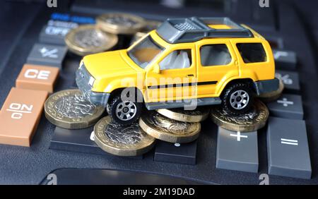MODEL SUV CAR ON ONE POUND COINS AND CALCULATOR RE MOTORING COSTS DRIVERS FUEL DIESEL PETROL REPAIRS ETC UK Stock Photo