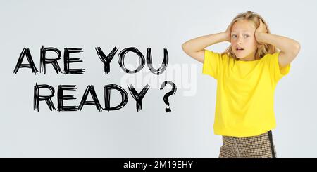 Education concept. A teenager girl holding her head in surprise. Isolated background. The text is written next to it - ARE YOU READY Stock Photo