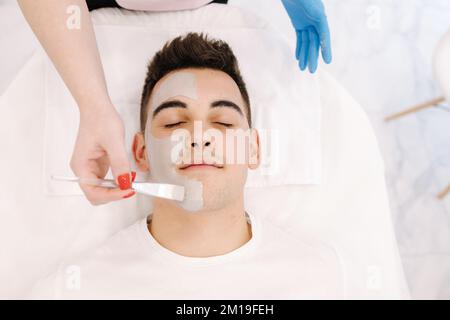 Top view of male in spa salon. Handsome man having cosmetic mask in beauty studio. Stock Photo