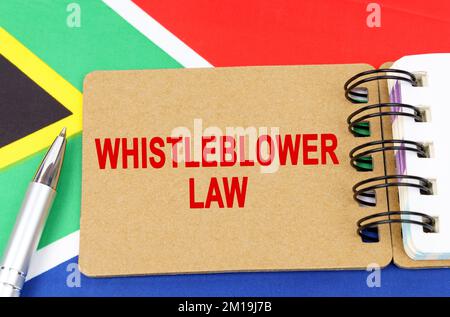 Law and justice concept. Against the background of the flag of South Africa lies a notebook with the inscription - WHISTLEBLOWER LAW Stock Photo