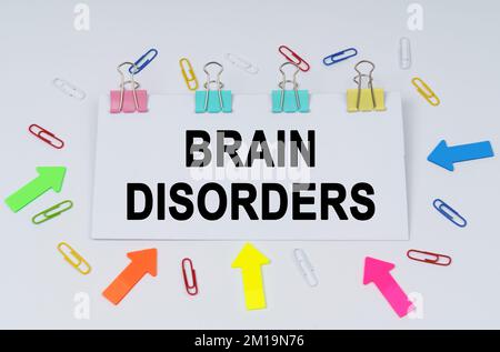 Business and finance concept. On the table there are paper clips and directional arrows, a sign that says - Brain Disorders Stock Photo