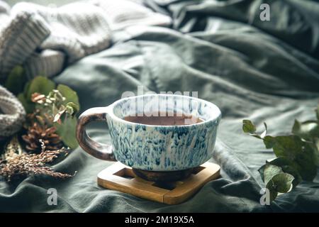 A cup of tea in bed on a blurred background. Stock Photo