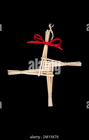 Saint Brigids Cross pagan symbol of house blessing protection from evil and fire. Traditionally made in Ireland on Imbolc St Brigids feast day. On bla Stock Photo