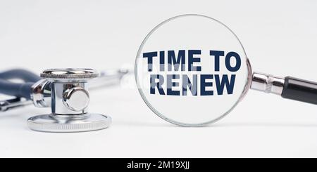 Medicine and health concept. There is a stethoscope on the table, a magnifying glass with the inscription - Time to Renew Stock Photo