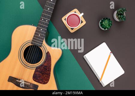 Flat lay, acoustic guitar and notebook on color background. Stock Photo