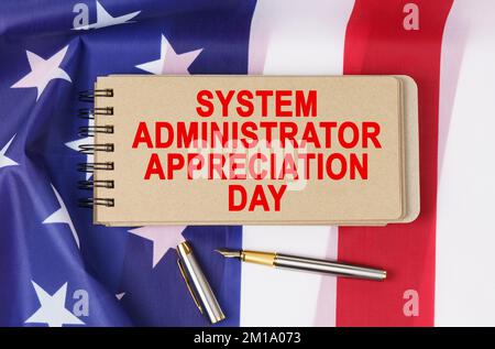 USA Holidays. Against the background of the US flag lies cardboard with the inscription - SYSTEM ADMINISTRATOR APPRECIATION DAY Stock Photo