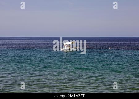 Lesbos scenes. Small fishing boat with family aboard, low in the water September / October 2022. Stock Photo