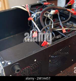 Desktop computer, black empty case and various cables, which are tried to be assembled in a home environment Stock Photo