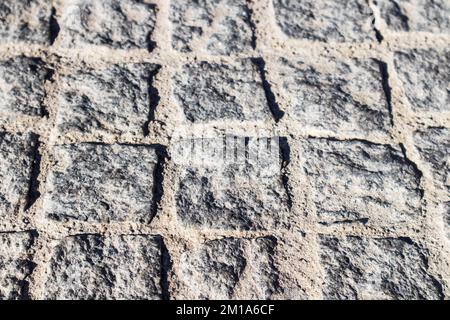 Gray, textured, bumpy cobblestone road Stock Photo