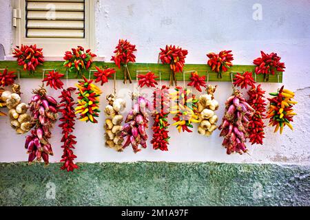 Vieste Gargano. Apulia Puglia Italy. Red chili,shallot and garlic hanged to dry outside a house Stock Photo